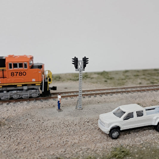 D-Type N Scale model railroad bi-directional signal with a scenic background.