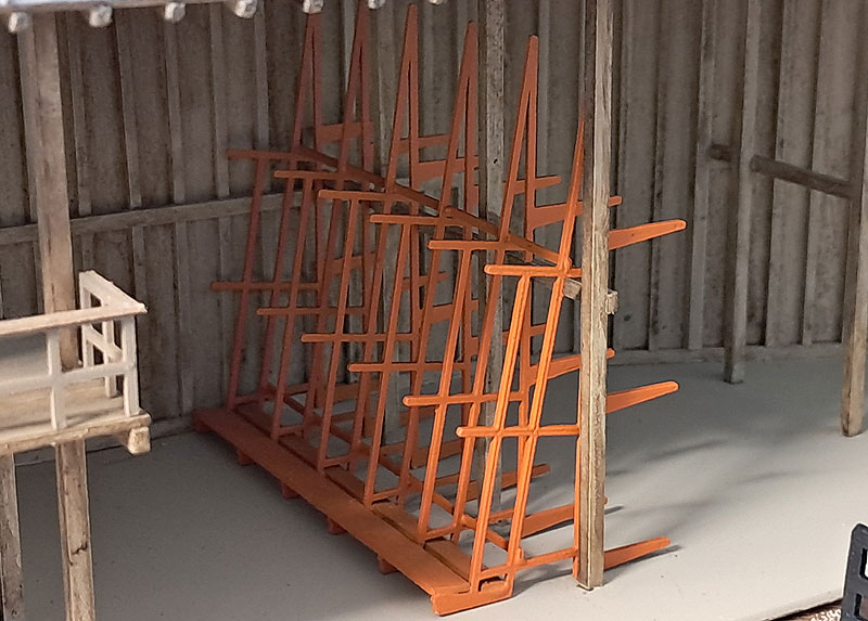 HO scale lumber storage racks painted orange.